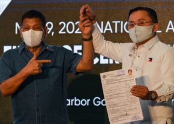 RODRIGO Duterte ketika mengiringi Christopher Lawrence Go yang menyerahkan pencalonan Naib Presiden Filipina di Manila, kelmarin. - AFP