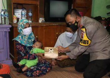 KETUA Polis Sukabumi, Lukman Syarif menyampaikan bantuan yang diberikan Joko Widodo kepada seorang wanita di Bojonggenteng, Indonesia. - AGENSI