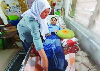 SUHAIDA Lim Tahir menjaga Muhammad Azli Danial yang kini terbaring di rumah mereka di Petri Jaya, Kota Tinggi selepas terlibat dalam kemalangan ketika dalam perjalanan menduduki kertas terakhir peperiksaan SPM bulan lalu.