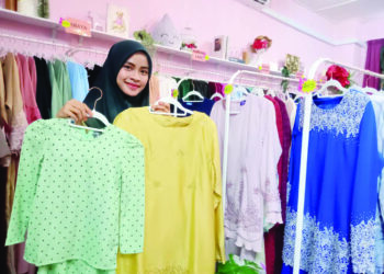 NUR Fildza Ezleen Salimi menunjukkan baju raya Rahmah yang dijual pada harga RM15 sepasang di butiknya, Manjalara Fashion Design di Taman Kota Masai, Pasir Gudang.