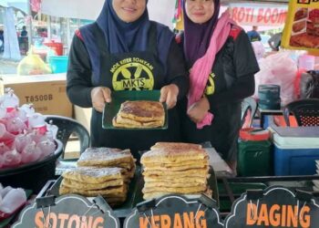 ASNITA Mat Zin (kiri) menunjukkan martabak inti sotong dan kerang yang dijual di Bazar Ramadan Gong Badak, Kuala Nerus, Terengganu. – UTUSAN/KAMALIZA KAMARUDDIN