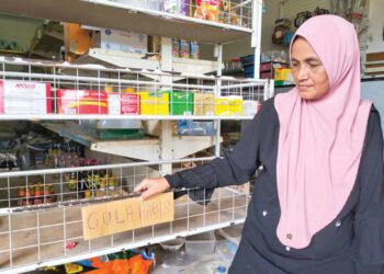 SAKINAH Ibrahim menunjukkan rak gula di kedainya kosong di Kampung Menjual, Tumpat, Kelantan-UTUSAN/ROHANA ISMAIL