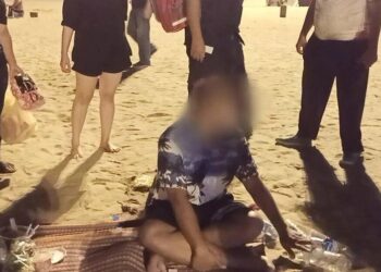 ORANG ramai membantu menyelamatkan mangsa yang sesak dada selepas menghisap ganja di pantai Pattaya.-AGENSI