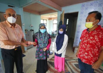 GAN Leong Piow (kiri) sambil perhatikan Lau Chit Fang menyerahkan sumbangan RM500 kepada Maz Irdhawati Mohd. Ali yang disalurkan secara bulanan sehingga dia dipanggil bertugas semula. – UTUSAN/ZULHANIFA SIDEK