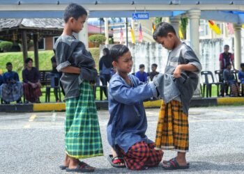 MUHAMMAD Afiq Habbibn Azizol (tengah) membetulkan ikatan kain pelikat adiknya, Muhamad Adib Habb (kanan) sambil diperhatikan Muhammad Aqil Habib (kiri) sebelum berkhatan dalam program Sinar Kedewasaan di Pusat Dakwah Islamiah Paroi dekat Seremban. - UTUSAN/MOHD SHAHJEHAN MAAMIN