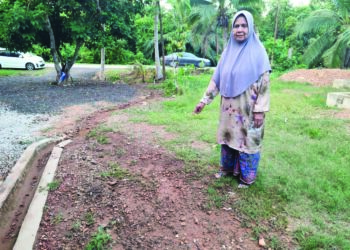 SEORANG penduduk yang menyaksikan insiden wanita dilanggar kereta dipandu suaminya menunjukkan lokasi kejadian di Kampung Bukit Tukang Jusoh, Kota Kuala Muda. - UTUSAN/NUR SYAZWANA MANSOR