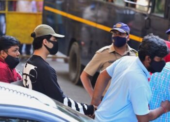 ARYAN Khan diiringi pegawai penguat kuasa di luar pejabat Biro Kawalan Narkotik di Mumbai. – AFP