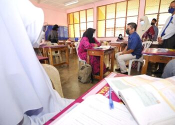 RADZI Jidin berbual dengan seorang pelajar tingkatan lima ketika mengadakan lawatan ke SMK Tunku Kurshiah, Kuala Pilah hari ini.-UTUSAN/MOHD. SHAHJEHAN MAAMIN.