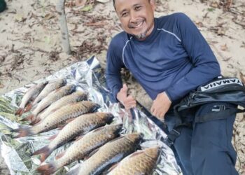 MUZAFFAR SYAM Mohamad bersama ikan kelah yang dipancing bersama rakannya di Jeram Perahu Ulu Tembeling, Jerantut, Pahang. - UTUSAN/SALEHUDIN MAT RASAD