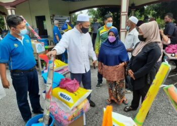 AWANG Hashim (dua dari kiri) berbual mesra dengan penerima sumbangan selepas Program Sumbangan Pasca Banjir oleh Perkeso kepada penduduk Parlimen Pendang di Pendang hari ini. - UTUSAN/MOHD. RIFAAT ABD. HAMID