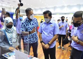 MOHD. SHAHAR Abdullah (tengah) diberikan penerangan oleh pegawai dari Ikip Trainning, Norsham Nisam Abdul Malik (dua dari kiri) pada Karnival Kerjaya MyFutureJobs Keluarga Malaysia di Dewan Paya Besar di Kuantan, Pahang. - UTUSAN/SHAIKH AHMAD RAZIF