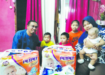 NORLIZA Mohd. Ali memangku Nurhidayah Mohd. Shaiful ketika menerima kunjungan Dzulkarnain Alias di Taman Sri Lambak, Kluang, Johor.