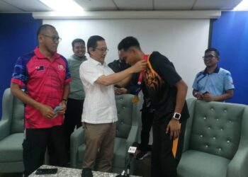 PENGERUSI YPIP,  Datuk Mohammad Khairi A. Malik mengalungkan pingat emas acara 400m Sukan SEA kepada Umar di Menara MBIP, Johor Bahru.