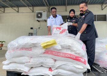 S. JEGAN (kiri) melihat tepung gandum yang dirampas di sebuah premis pengilang roti, di George Town, Pulau Pinang semalam kerana didapati disimpan tanpa permit yang sah yang dalam sidang akhbar di Bukit Mertajam hari ini.