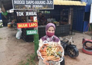 NUR Shella Abdullah menunjukkan ‘mi segera janda anak ramai’ yang menggabungkan pelbagai makanan laut di Meggi Dapo Arang Jijo di Tok Jembal, Kuala Nerus, semalam.