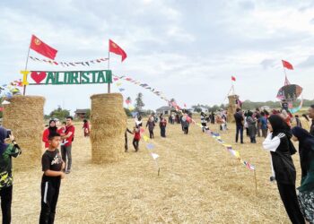 ORANG ramai tidak melepaskan peluang beriadah di kawasan bendang yang dihiasi jerami gulung di Kampung Kelompang, Tok Keling di Alor Setar. - UTUSAN/JAMLIAH ABDULLAH