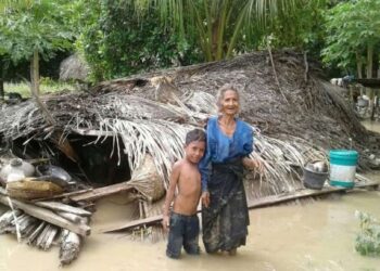 SEORANG wanita warga emas bersama cucunya berdiri di depan rumah mereka yang musnah akibat banjir lumpur di Haitimuk, Flores Timur, Indonesia. - AFP