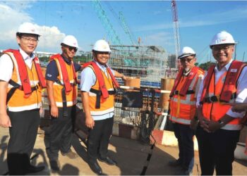 LEE Ting Han (kiri) dan Mohamad Fazli (tiga dari kiri) melihat projek landasan RTS Link yang dalam pembinaan merentasi Selat Tebrau ketika mengadakan lawatan ke tapak projek tersebut di Johor Bahru. - UTUSAN/ RAJA JAAFAR ALI