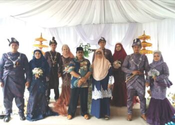 SUBHI Othman (bersongkok/tengah) dan Rohani Md. Tan bersama empat pasangan pengantin yang bersanding serentak dalam satu majlis perkahwinan di Felda Bukit Cherakah, Klang, Selangor.