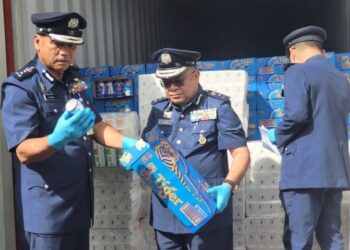 JULAIMAN Soimin (kiri) memeriksa minuman keras yang dirampas di Pelabuhan Sepanggar di Kota Kinabalu hari ini.