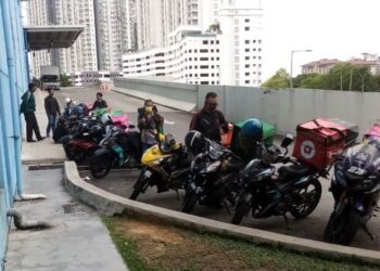 PEKERJA penghantar makanan sedang menunggu makanan yang dipesan pelanggan dekat sebuah pusat membeli-belah di Seksyen 13, Shah Alam, Selangor, hari ini. - UTUSAN / MOHAMAD NAUFAL MOHAMAD IDRIS