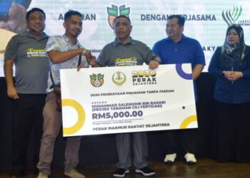 SAARANI Mohamad (tengah) menyampaikan skim pembiayaan pinjaman tanpa faedah kepada pengusaha projek tanaman cili fertigasi pada Karnival Sekuriti Makanan@Perak Sejahtera 2030 di Padang Rengas semalam. UTUSAN/ZULFACHRI ZULKIFLI.