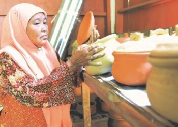 ZAINAB Hussin menunjukkan produk tembikar di bengkel miliknya di Kampung Mambong, Kuala Krai, Kelantan. – UTUSAN/KAMARUL BISMI KAMARUZAMAN