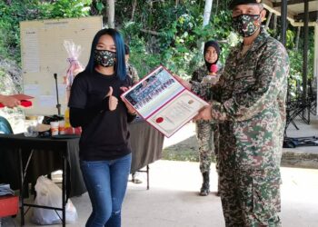 MOHD. Halim Khalid (kanan) menyampaikan sijil penghargaan kepada salah seorang pengamal media yang hadir dalam program Hari Bersama Media di Markas Divisyen Kelima Infantri di Kota Kinabalu hari ini.