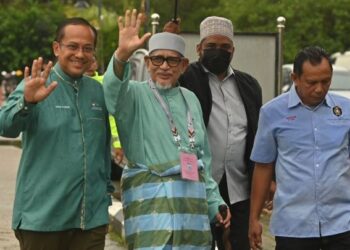 ABDUL Hadi Awang (dua, kiri) diiringi Ahmad Samsuri Mokhtar (kiri)  tiba di pekarangan Pusat Penamaan Calon, Pejabat Daerah dan Tanah Marang, Marang, hari ini. -  UTUSAN/PUQTRA HAIRRY ROSLI