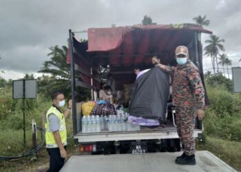 Pasukan bomba membantu proses penghantaran pulang mangsa banjir di Kota Marudu, hari ini.