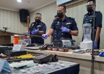 AHMAD Ridhwan Mohd. Nor @ Saleh (tengah) menunjukkan antara barangan di rampas dalam dua operasi berasingan berkaitan kes samun dan dadah di IPD Kuala Langat, Selangor, hari ini.