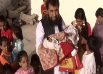 SARDAR Jan Mohammad Khan Khilji (tengah) mendukung bayinya yang baharu lahir sambil dikelilingi anak-anaknya.-AGENSI