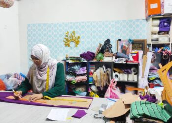 MAZLILAH Ngah menyiapkan tempahan jahitan pakaian pelanggannya sempena sambutan Hari Raya Aidilfitri di Kampung Pasir Panjang, Kuala Terengganu. - UTUSAN/KAMALIZA KAMARUDDIN