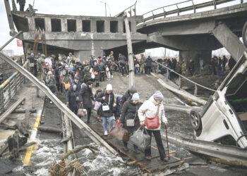 ORANG ramai berjalan di atas jambatan runtuh di bandar Irpin, barat laut Kyiv ketika tentera Rusia dan Ukraine bertempur. - AFP