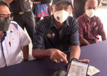 ROSOL Wahid (tengah) menunjukkan gambar gegelang sotong yang tular di media sosial didakwa diperbuat daripada dubur atau usus babi di Masjid Kampung Mak Kemas, Marang hari ini.