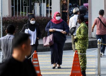 SITI Bainun Ahd. Razali (tengah) tiba di mahkamah sambil diiringi peguamnya bagi menghadiri prosiding pertuduhan mengabai dan menganiaya remaja sindrom Down dikenali sebagai Bella di Kompleks Mahkamah Kuala Lumpur. – UTUSAN/MUHAMAD IQBAL ROSLI