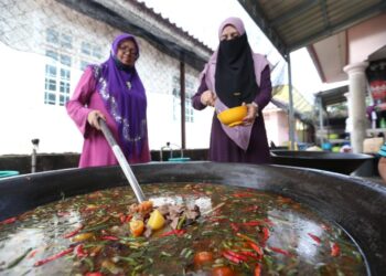 ZURAWATI Zulkifli (kanan) memasak daging singgang untuk diagihkan kepada golongan asnaf di Tanjung Mas Kota Bharu, Kelantan. 
– UTUSAN/ ROSLIZA MOHAMED