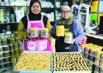 NORJANBEE Omar (kanan) dan adiknya, Ismabee Omar menunjukkan sebahagian daripada biskut dan kuih raya yang sering mendapat permintaan tinggi daripada pelanggan ketika ditemui di rumah mereka di Butterworth, Pulau Pinang.
