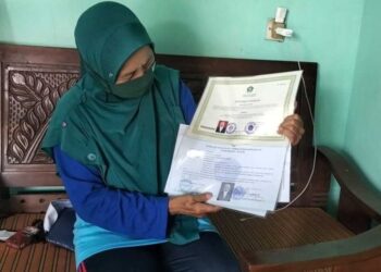 SUWARTI menunjukkan sijil pendidikan yang pernah diterimanya sebelum bergelar guru di Jawa Tengah.-KOMPAS