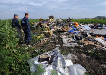 ANGGOTA penyelamat melihat bangkai pesawat Malaysia Airlines, MH17, dua hari selepas ia ditembak jatuh di timur Ukraine pada Julai 2014. - AFP