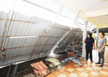 L. Saraswathy (kiri) melihat bumbung yang runtuh akibat dipukul ribut di Pusat Jagaan Warga Istimewa Kempas, Johor Bahru, Johor. - UTUSAN/RAJA JAAFAR ALI