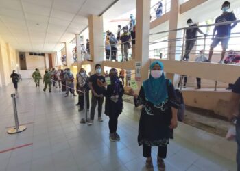 Penerima vaksin secara walk-in masih menunggu giliran untuk memasuki dewan PPV di UMS, Kota Kinabalu hari ini.