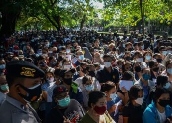 ORANG ramai menunggu giliran pendaftaran vaksin AstraZeneca di Denpasar, Bali. – AFP