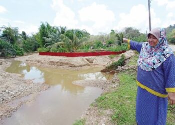 SITI Khadijah Hamid menunjukkan sungai berdekatan rumahnya yang cetek di Kampung Belukar Bukit, Hulu Terengganu, Terengganu. - UTUSAN/NOOR HAYATI MAMAT