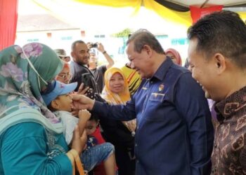 AMINUDDIN Harun (tengah) beramah mesra dengan hadirin pada Majlis Pecah Tanah Lot Kediaman Harapan Generasi Baru Felda Palong Fasa 1 di Felda Palong 12, Jempol hari ini.- UTUSAN/NOR AINNA HAMZAH