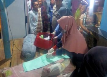 PENDUDUK melihat pegawai kesihatan merawat salah seorang bayi yang ditemui dibuang di daerah Serang di Banten baru-baru ini.-AGENSI