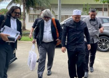 EBIT Lew (dua kanan) bersama peguamnnya Ram Singh (tengah) dan Kamarudin Mohmad Chinki semasa tiba di Mahkamah Majistret Tenom