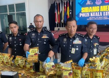 Yahaya Othman (dua dari kiri) menunjukkan bungkusan dadah dirampas di Kontinjen Kuala Lumpur hari ini.