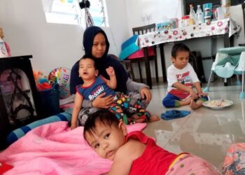 SAIZANA Ermah Hamdan menjaga tiga anaknya yang merupakan OKU di Simpang Tiga, Rungkup di Bagan Datuk. - UTUSAN/AIN SAFRE BIDIN