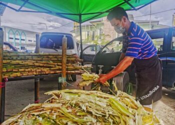 ABDUL Rashid Ismail menunjukkan kerja kerja  mengisar tebu bagi mengambil airnya untuk dijual di Bazar Ramadan Membakut, Kimanis.